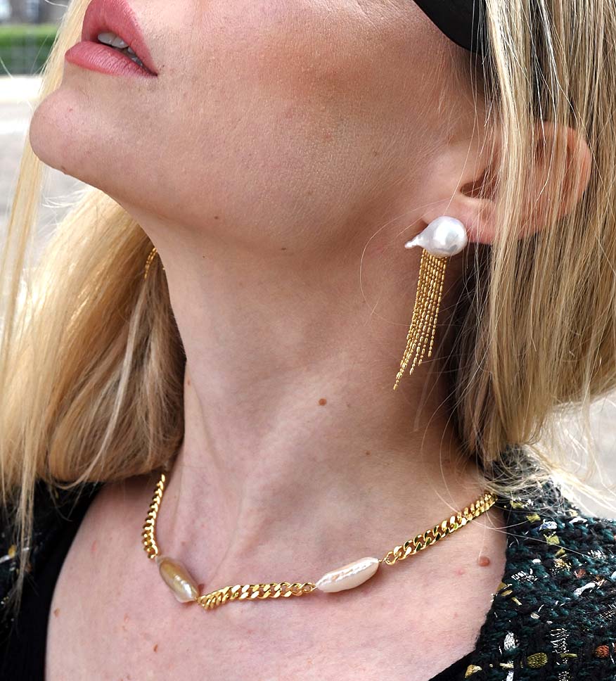 Confident woman wearing a bold Cuban pearl choker necklace for a Nordic-inspired statement look