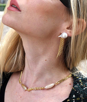 Confident woman wearing a bold Cuban pearl choker necklace for a Nordic-inspired statement look