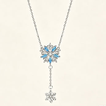 Minimalist sterling silver necklace featuring a double snowflake drop pendant on a delicate chain, shot against a clean neutral background.