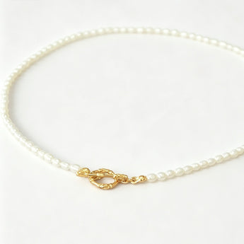 Pearl necklace with a gold clasp on a white background