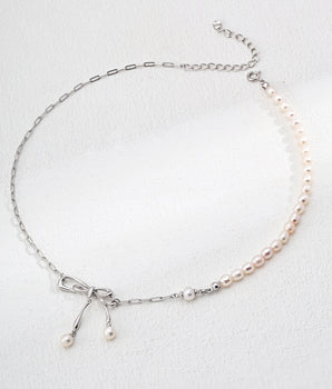 Amélie Bow Pearl Necklace featuring freshwater pearls and Silver-paper chain, artfully arranged with the delicate bow accent visible. Adjustable 40cm+5cm chain shown on neutral background for effortless styling