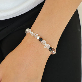 Woman wearing a unique white crystal and black jade healing bracelet as a stacking bracelet