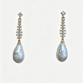 Pair of pearl earrings with diamond-like stones on a white background