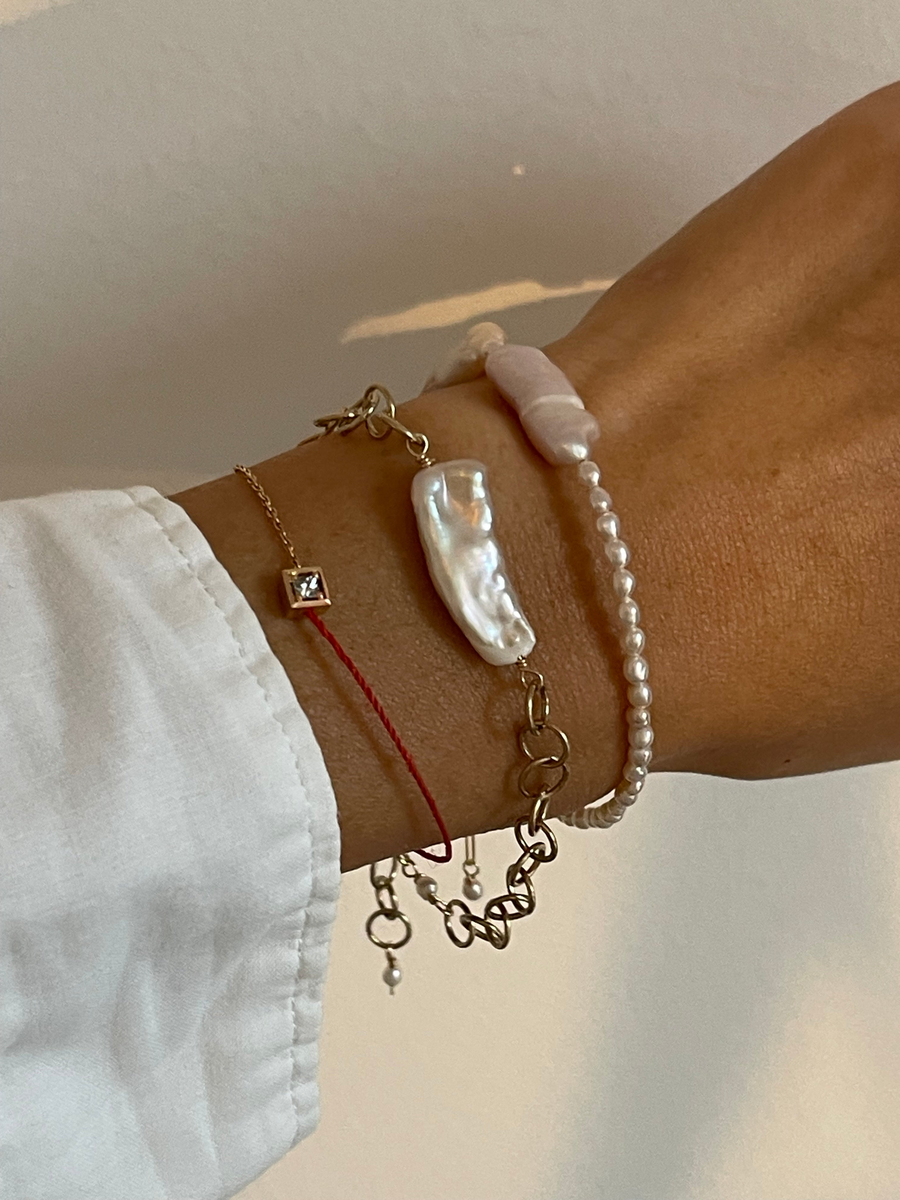 Minimalist Scandinavian jewelry collection featuring organic pearl bracelet with gold chain 。