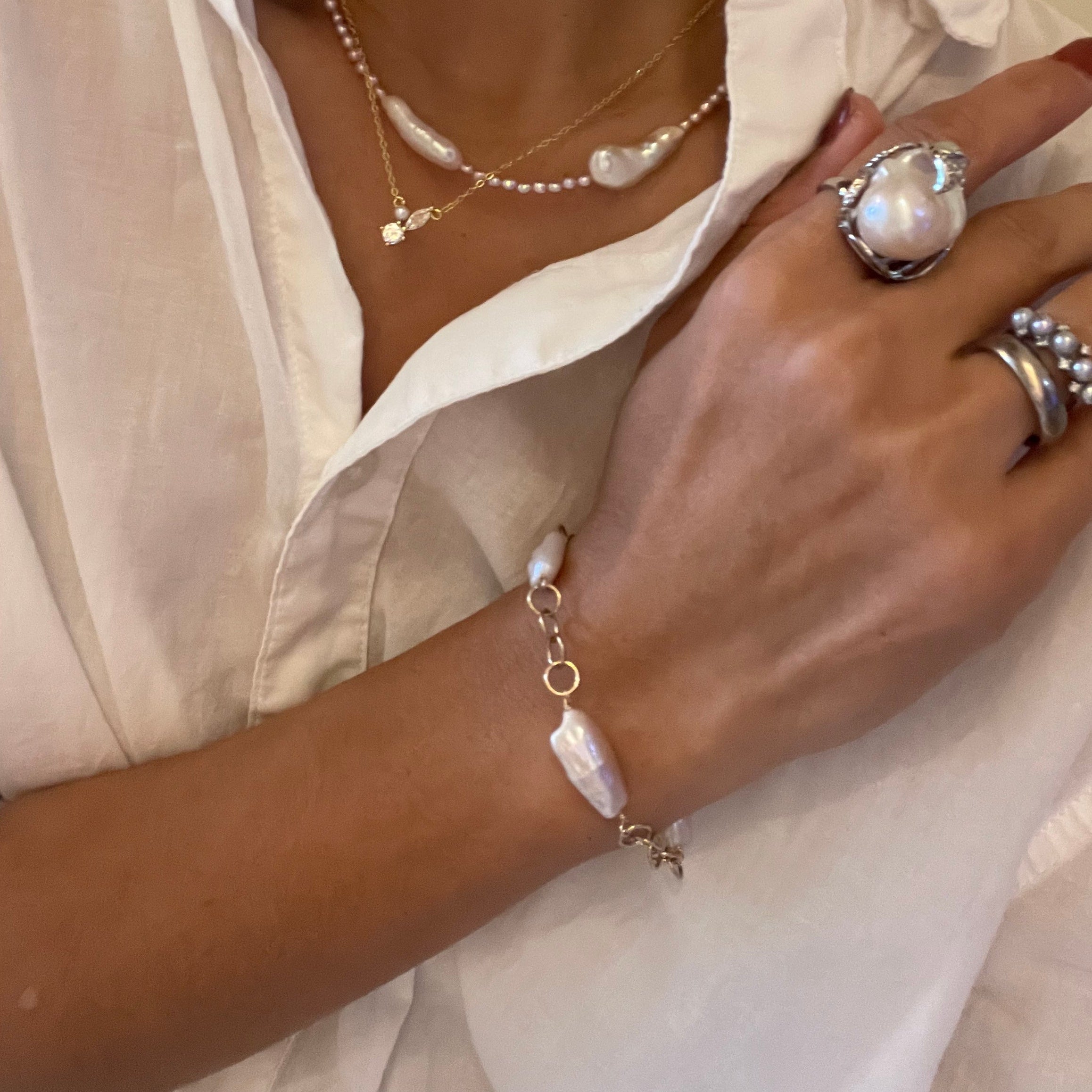 Sun-kissed wrist wearing adjustable pearl bracelet - effortless Copenhagen elegance