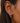 Close-up of an ear wearing a colorful earring with a blurred background