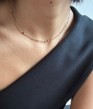 Close-up of a person wearing a beige hat and dark shirt against a light background
