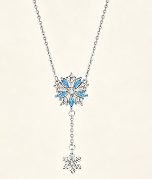 Minimalist sterling silver necklace featuring a double snowflake drop pendant on a delicate chain, shot against a clean neutral background.