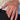 A close-up of a hand wearing a rose gold ring with an emerald-cut clear gemstone, styled with a cream lace top and black pants.