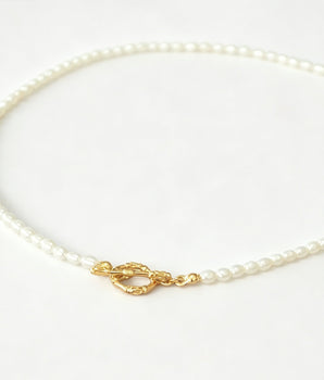 Pearl necklace with a gold clasp on a white background