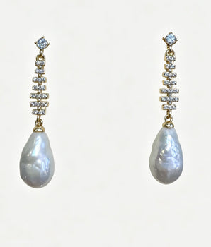 Pair of pearl earrings with diamond-like stones on a white background
