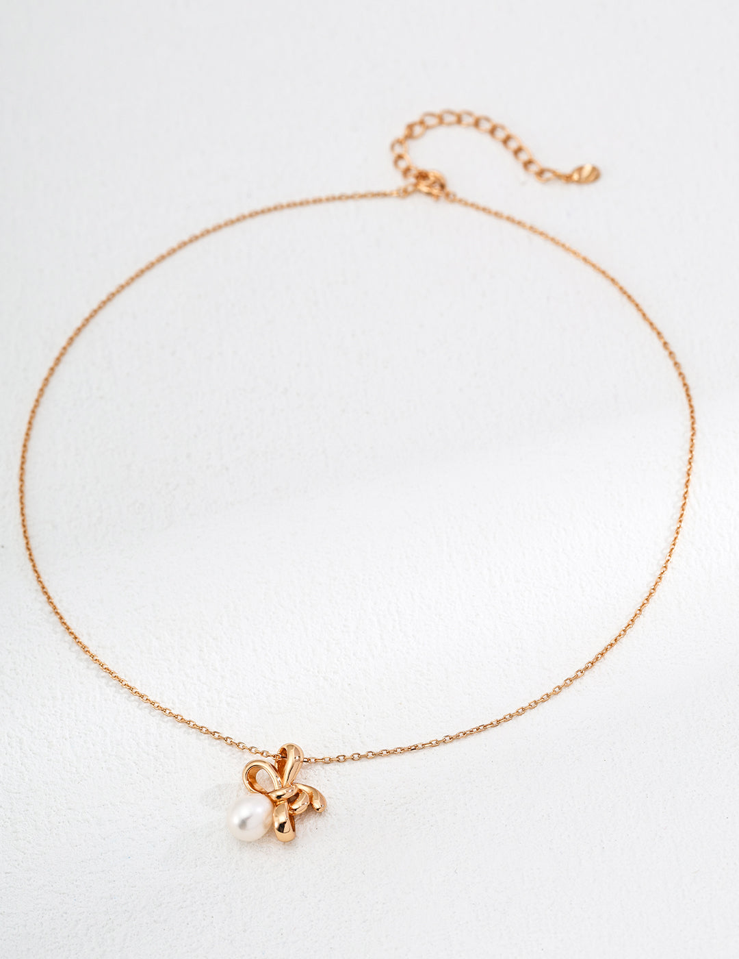 Handcrafted bow pendant with iridescent freshwater pearl on gold vermeil chain